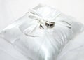 White ring cushions with wedding rings