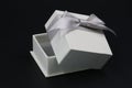 White ring gift box with silver bow isolated on a black background Royalty Free Stock Photo