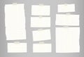 White ripped striped note, notebook paper for message or text stuck with sticky tape on gray background. Royalty Free Stock Photo