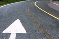 White road arrow direction sign on the asphalt road. Royalty Free Stock Photo