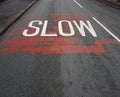 White road sign slow speed limit painted onto the road Royalty Free Stock Photo