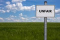 White road sign. the word UNFAIR is displayed. The sign stands on a field with blue background