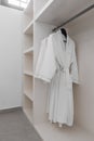 white robes with wooden hangers at dressroom. Royalty Free Stock Photo