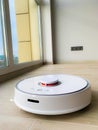 White robot cleaner. Robot vacuum cleaner on laminate floor in action Royalty Free Stock Photo