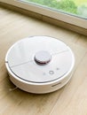 White robot cleaner. Robot vacuum cleaner on laminate floor in action Royalty Free Stock Photo