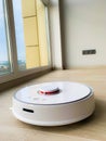 White robot cleaner. Robot vacuum cleaner on laminate floor in action Royalty Free Stock Photo