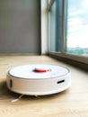 White robot cleaner. Robot vacuum cleaner on laminate floor in action Royalty Free Stock Photo