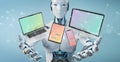 White robot connecting modern smartphone tablet laptop and computer 3D rendering Royalty Free Stock Photo
