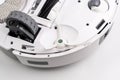 A white robot with a green wheel on the bottom