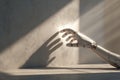 White robotic arm reaching for sunlight streaming into empty room, casting shadow on wall Royalty Free Stock Photo