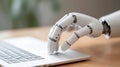 A white robotic hand on a laptop.