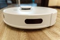 Modern white robotic vacuum cleaner. Self Drive Cleaning Robot. Floor Cleaning System. Selective focus