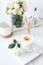 White room interior decor with burning hand-made candle and bouq Royalty Free Stock Photo