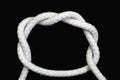 A white rope tied with double overhand knot on black background