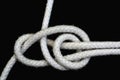 A white rope tied with double sheet bend knot on black background Royalty Free Stock Photo