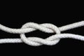 A white rope tied with granny knot on black background Royalty Free Stock Photo
