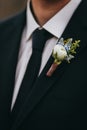 White rose and blue flowers boutonniere on groom's black suit w Royalty Free Stock Photo