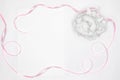 White rose decor and blank white paper card with pink satin ribbon on white background. Copy space. Wedding mock-up Royalty Free Stock Photo