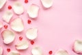 White rose petals and hearts on pink background. Valentines Day or Mothers Day abstract background. Love concept. Royalty Free Stock Photo