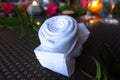 White rose shaped napkin on candlelit table