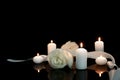 White roses and burning candles on black mirror surface in darkness, space for text. Funeral symbols Royalty Free Stock Photo