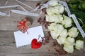 White roses with laces, red heart, gift box, key and paper for your text on wooden background Royalty Free Stock Photo