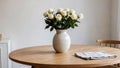 White roses in paunchy vase on round wooden brown table against empty gray wall. Minimalistic interior. Scandinavian style