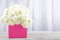 White roses in a pink square box close-up on a white background. Royalty Free Stock Photo