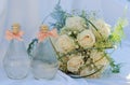 White roses wedding bouquet with a bottles