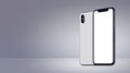 White rotated smartphones similar to iPhone X mockup front and back sides on gray background banner with copy space