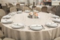 The white round banquet table in the restaurant is decorated with fresh flowers. Stylish event decor Royalty Free Stock Photo