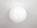 White round ceiling lamp on a white ceiling. Paper round lampshade Royalty Free Stock Photo