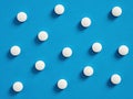 White round medical pills on blue background. Medical and pharmaceutical treatment concept Royalty Free Stock Photo