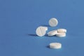 White round medical pills on a blue background Royalty Free Stock Photo