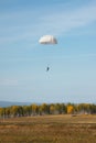 White round parachute on the background of the autumn landscape.