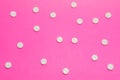 White round pharmacological tablets are on a pink polka dot background. Drug designation concept for women, gynecological drugs Royalty Free Stock Photo