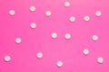 White round pharmacological tablets are on a pink polka dot background. Drug designation concept for women, gynecological drugs