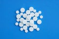 White round pills on a blue background.