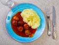 white round plate with meatballs sprinkled with chopped dill in tomato sauce with mashed potatoes Royalty Free Stock Photo