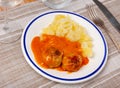 white round plate with meatballs sprinkled with chopped dill in tomato sauce with mashed potatoes Royalty Free Stock Photo