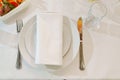 White round plate with serving napkin on table. Royalty Free Stock Photo