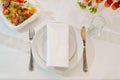 White round plate with serving napkin on table. Royalty Free Stock Photo