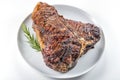 White round plate with Whole grilled T-bone steak and rosemary