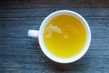 White round porcelain tea cup with fresh herbal green tea. Hot healthy beverage for breakfast. Wooden background. top