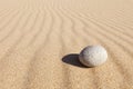 White round stone lying on clean sand. Concept of balance, harmony and meditation. Minimalism Royalty Free Stock Photo
