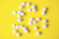White round tablets on yellow background, top view Royalty Free Stock Photo