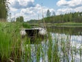 A white rubber boat on an overgrown river bank Royalty Free Stock Photo