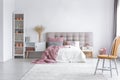 Bright bedroom interior with comfortable bed with headboard and white wooden furniture Royalty Free Stock Photo