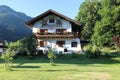 The White, rural, two-storeyed House in the foothills of the Alps.