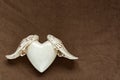 White rustic heart with wings on soft brown fleece fabric. conceptually for love and freedom